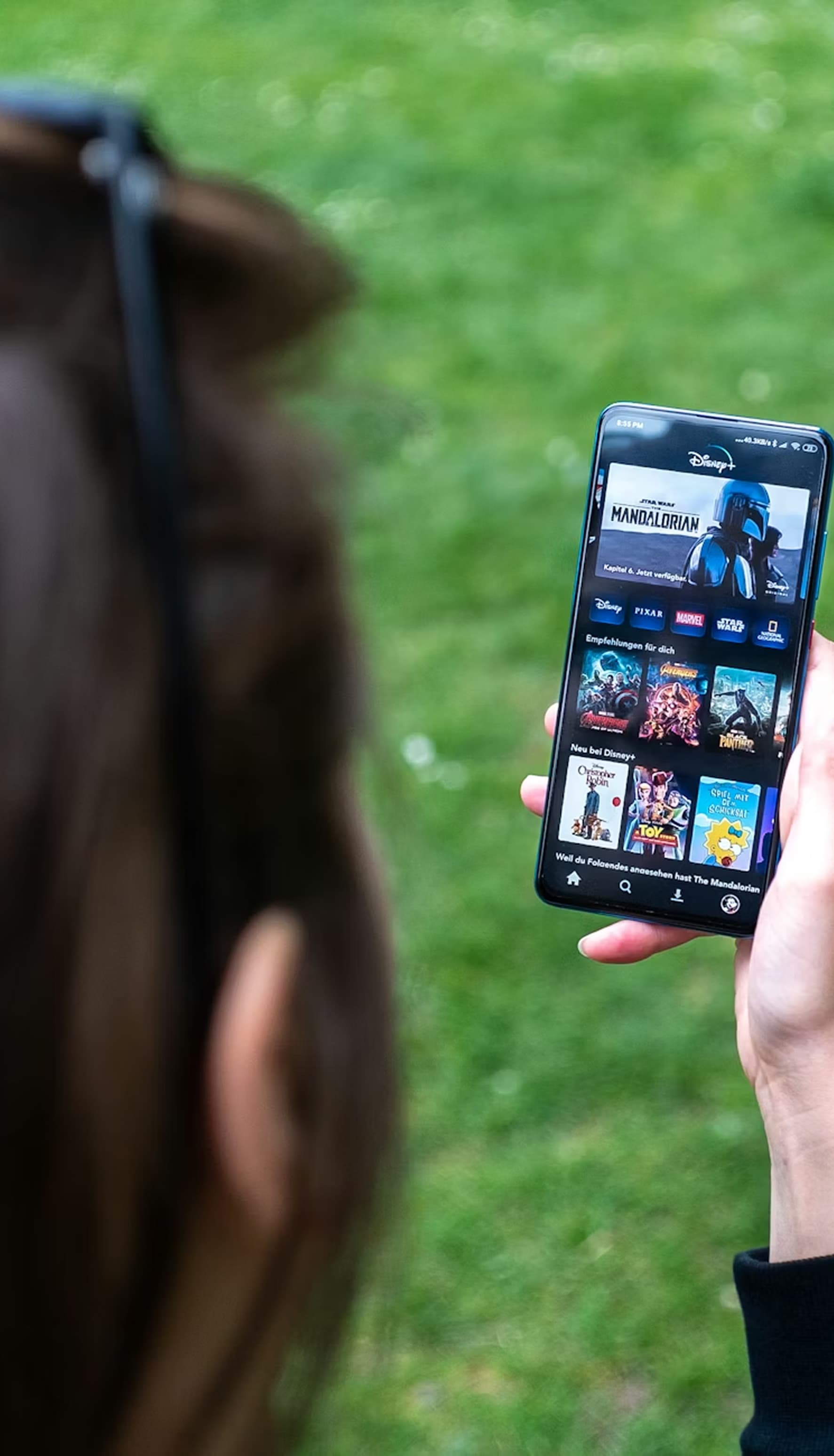 Person watching IPTV on smartphone outdoors